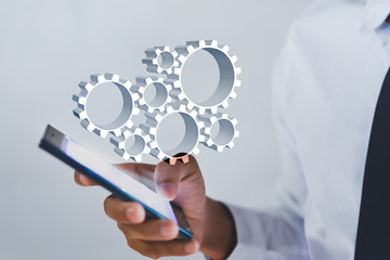 Businessman working smartphone and gears system on virtual screen, business process management and...