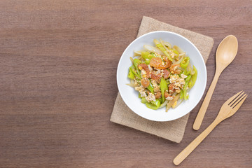 top view of stir fried banana pepper with egg and dried shrimp in a ceramic bowl on wooden table. asian homemade style food concept.