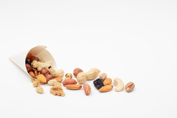Assorted  Nuts  spill out of a paper cone on white background