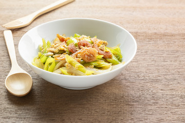 stir fried banana pepper with egg and dried shrimp in a ceramic bowl on wooden table. asian homemade style food concept.
