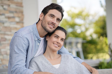 Fototapeta premium Portrait of very attractive couple smiling outside modern house