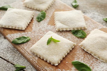 Tasty ravioli on wooden board, closeup