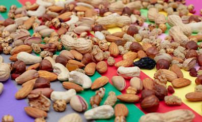 Assorted nuts scattered on a colorful paper background