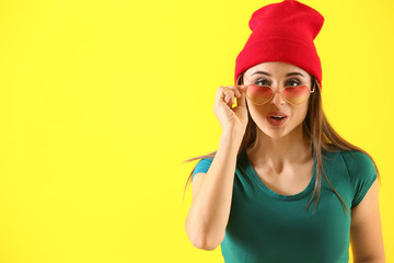 Emotional young woman after making mistake on color background