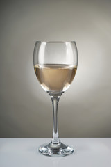 Glass of white wine on grey background