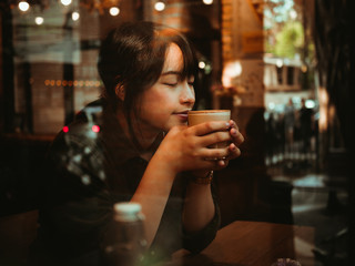 Asian woman drinking coffee in  coffee shop cafe
