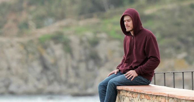 Sad teen contemplating ocean complaining from a terrace in a coast town