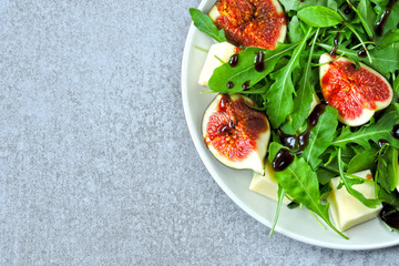 Bright healthy arugula fig salad. Fitness food. Colorful, healthy foods in flatlay style