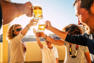 Group of people families and friends having fun together clinking with beers and orange juice -...