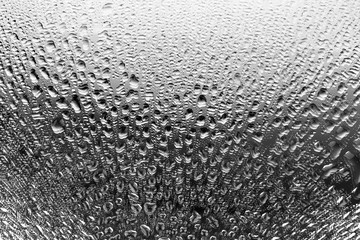 Monochrome image mirror glass surface with water drops, black and white gradient, shiny dew, rain or liquid on the glass surface, wet moist texture background close up