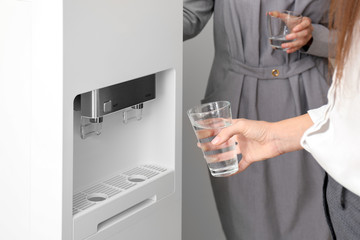 Women having break near water cooler in office