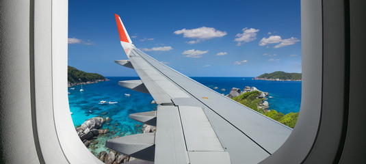 View from airplane. Flight window. Vacation destinations. Tropical beach. Travel concept.
