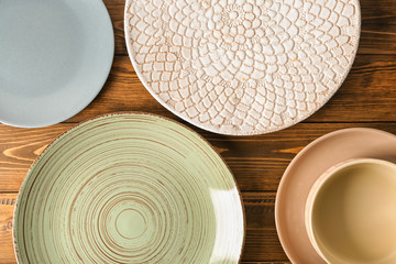 Set of clean tableware on wooden background, top view