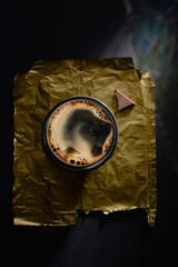 Coffee top view with chocolate on the black table and gold pattern - premium photo