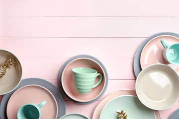 Set of clean tableware on color wooden background