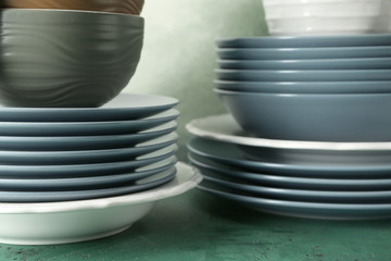 Set of clean dishware on color table