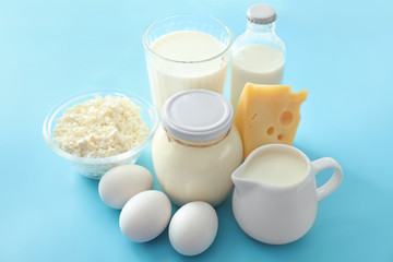 Tasty dairy products with eggs on color table