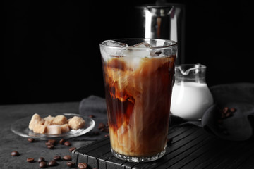 Glass of cold coffee on dark table