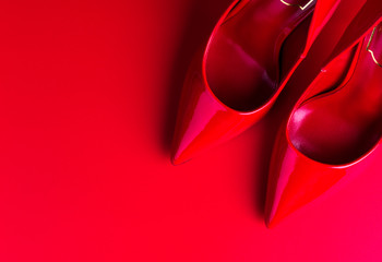Top view of red high heel women shoes on red background