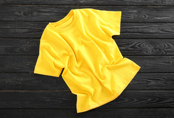 Blank yellow t-shirt on wooden background