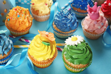 Delicious cupcakes with party decor on color background