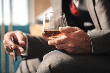 Mature businessman wearing hand watch smoking cigar after work