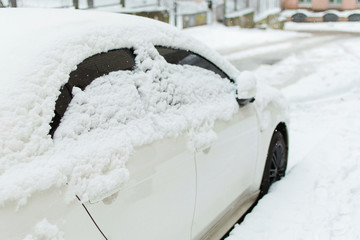 White car covered with snow.