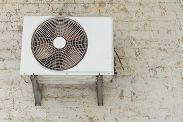 Outdoor air conditioning unit on the wall of the building.