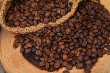 A sack of roasted coffee beans on wooden