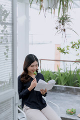 Fototapeta premium The beautiful girl in a summer cafe reading a book
