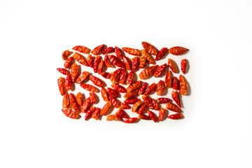 A pile of spicy chillies leaning on a white background in the shape of a rectangle