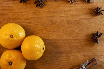 orange mandarins and cinnamon sticks and anise stars  on the wooden table 