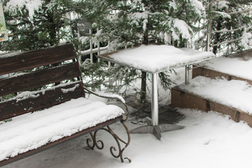 Snowfall. Street shop and a table covered with snow.