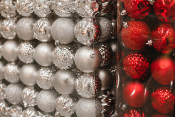 Lot of colorful red and silver glass christmas balls in plastic boxes sold in supermarket