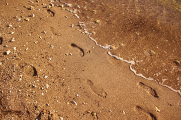 human foot print on sand sea beach south waterfront shore line background texture summer vacation holidays concept