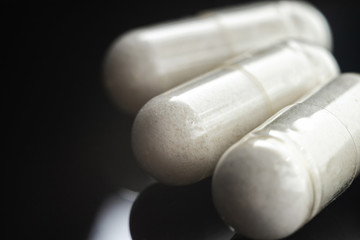 White medical capsules of glucosamine chondroitin, healthy supplement pills, macro image