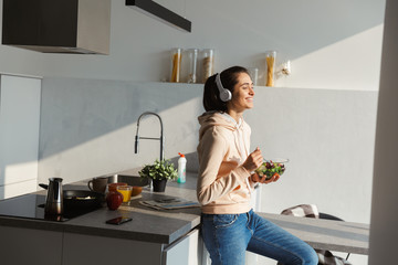 Cheerful young girl listening to music with headphones