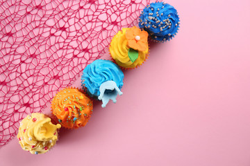 Delicious cupcakes on color background