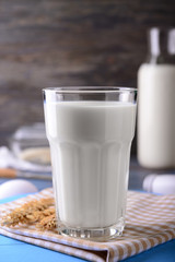 Glass of milk on color wooden table