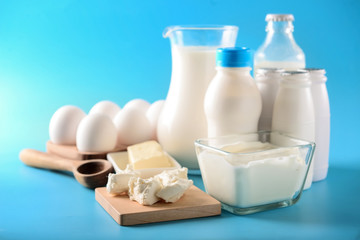 Different milk products with eggs on color background