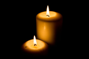 Burning candle in darkness