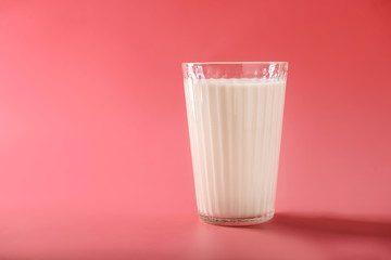 Glass of milk on color background