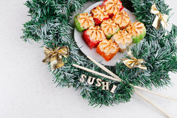 Christmas sushi. New Year sushi. Sushi and Christmas wreath and the Word SUSHI. View from above.