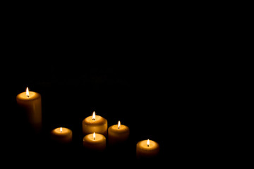 Burning candle in darkness