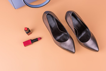 Fashionable accessories concept. Thick high heels and bag, lipstick. Pair of fashionable high silver shoes