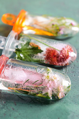 Popsicles with flowers on color background