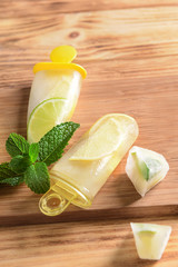 Popsicles with cutting board on wooden background