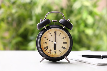 Alarm clock on white table outdoors