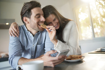  Gorgeous fun couple feeding eachother cookies in modern kitchen