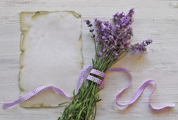 Lavender flowers  with paper on wooden background 
